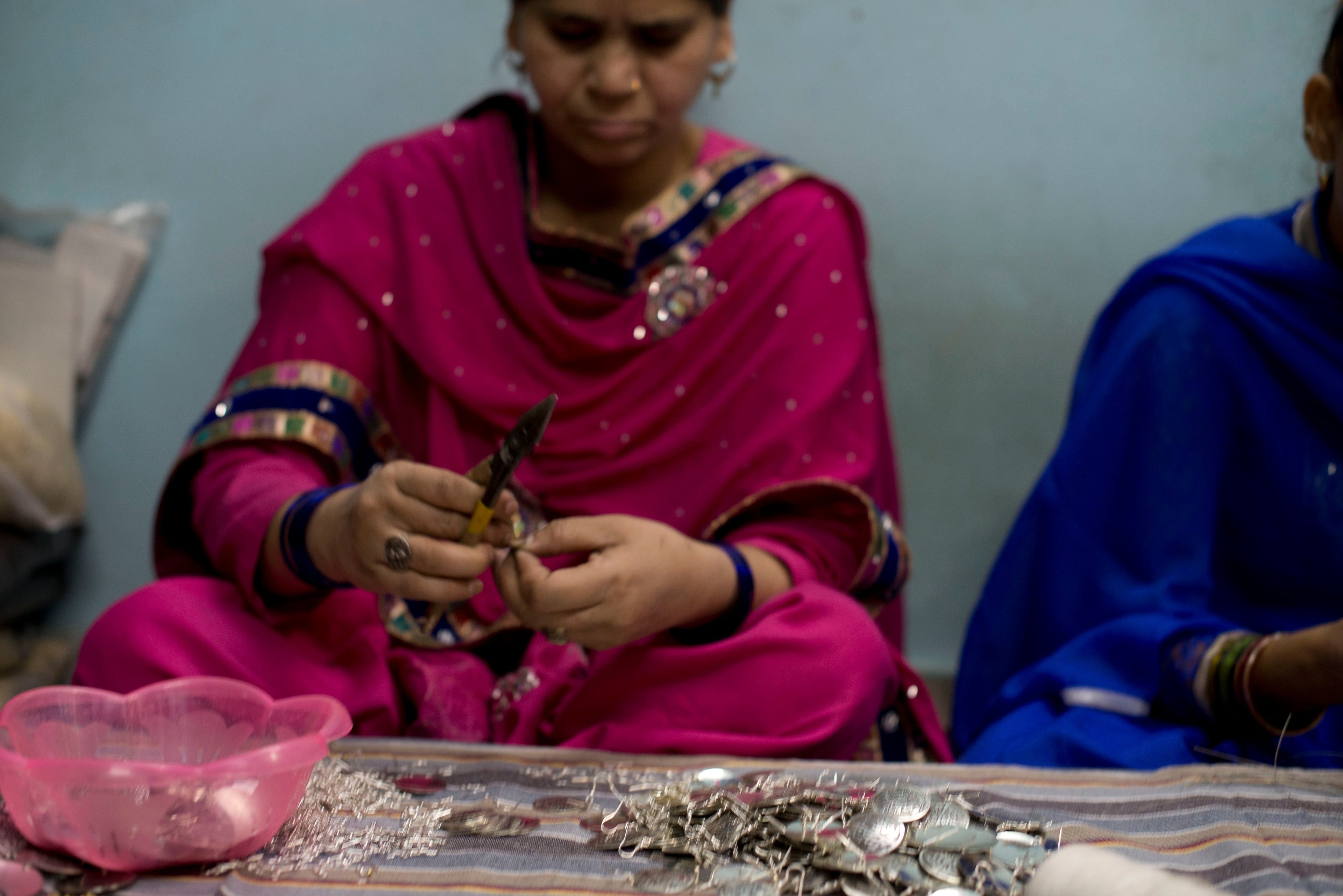 Woman artisan from India shown making jewelry. This is a marketing photo provided by Matr Boomie.